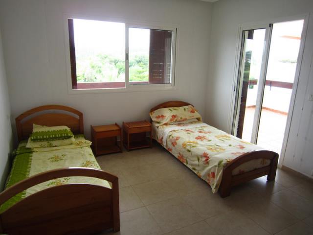 une chambre avec deux lits et un terrasse